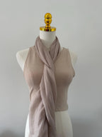 Mannequin wearing a beige ribbed tank top and pink scarf against a plain background