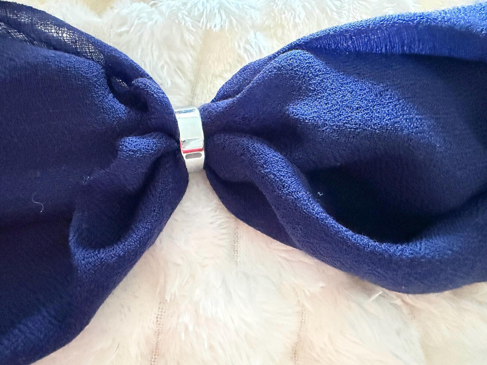 Close-up of a blue bow on a textured white background