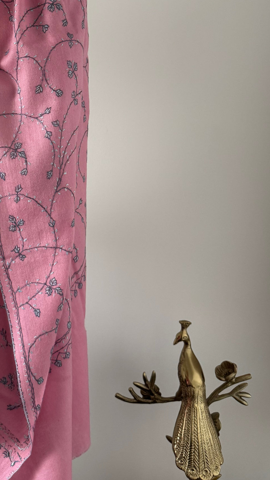 Pink fabric with floral pattern on a mannequin against a plain background