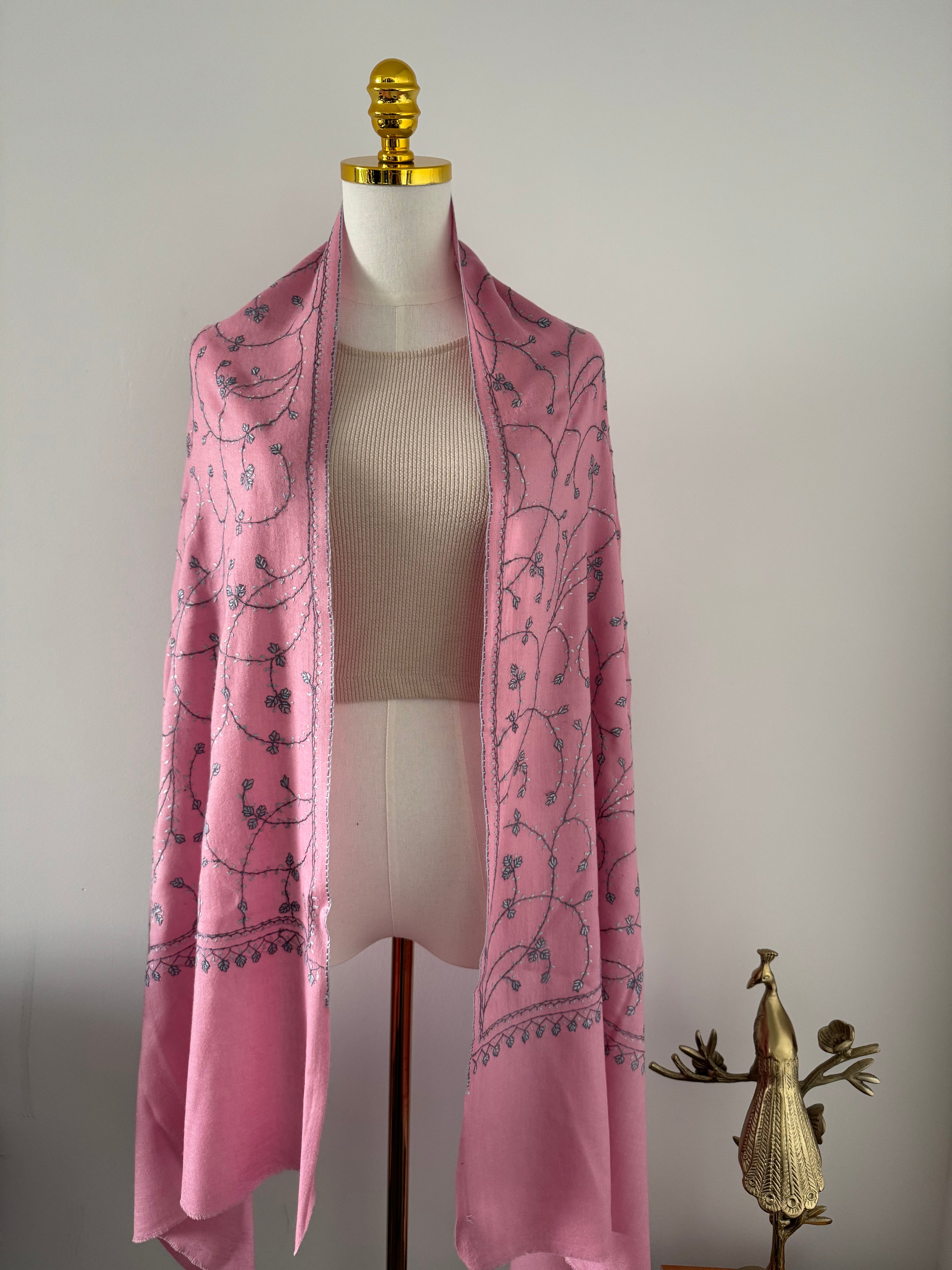 Pink fabric with black floral pattern on a white mannequin against a plain background