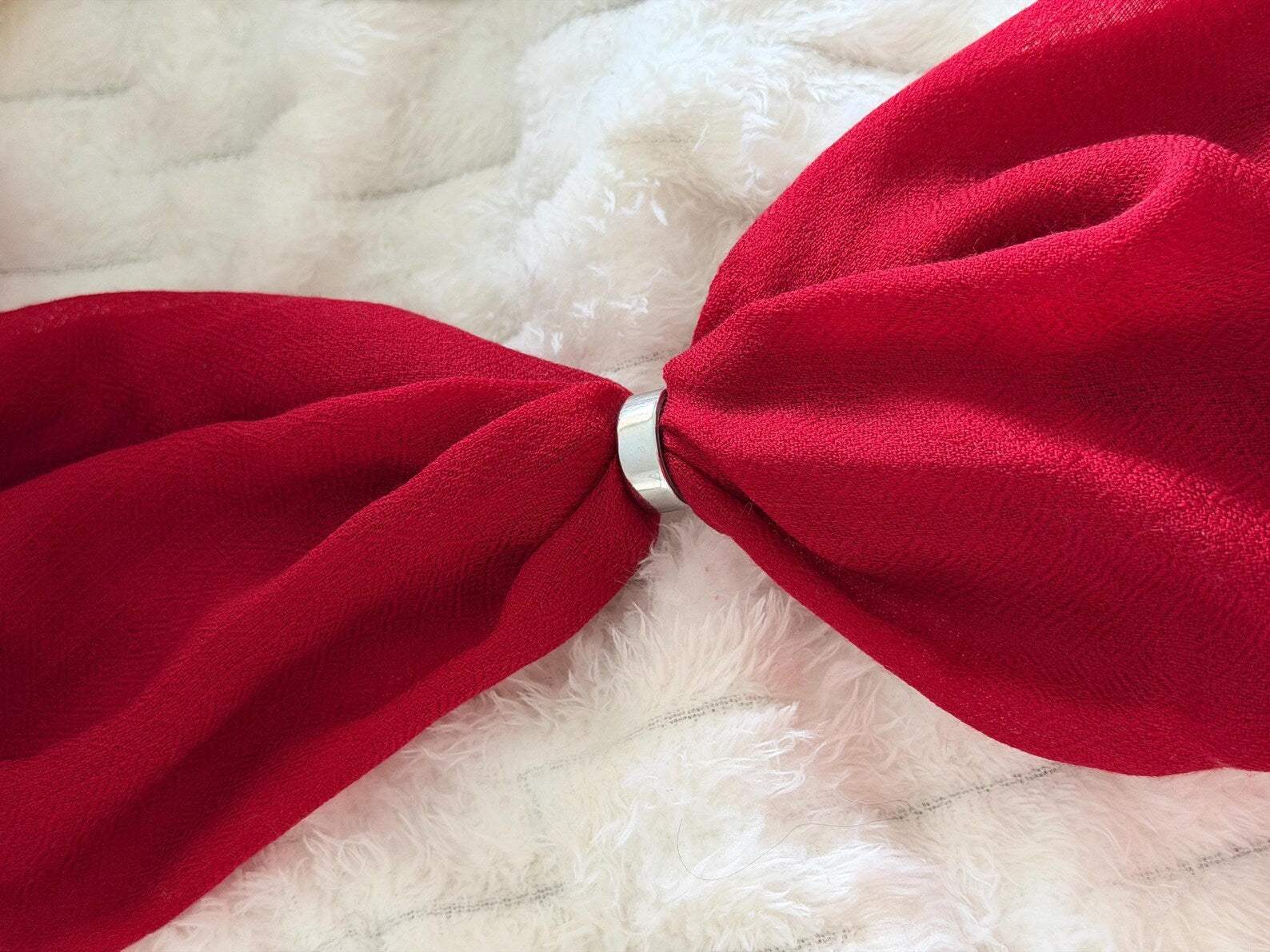 Red bow headband on a white fur background
